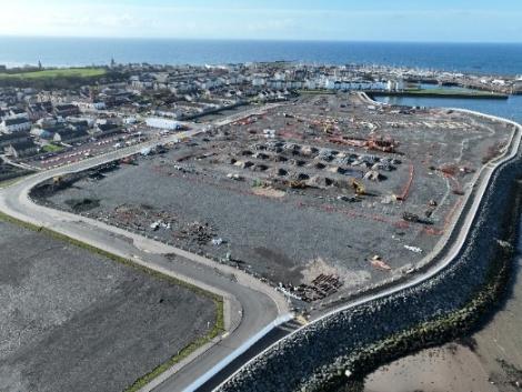Aerial view of construction site surrounded by the sea.