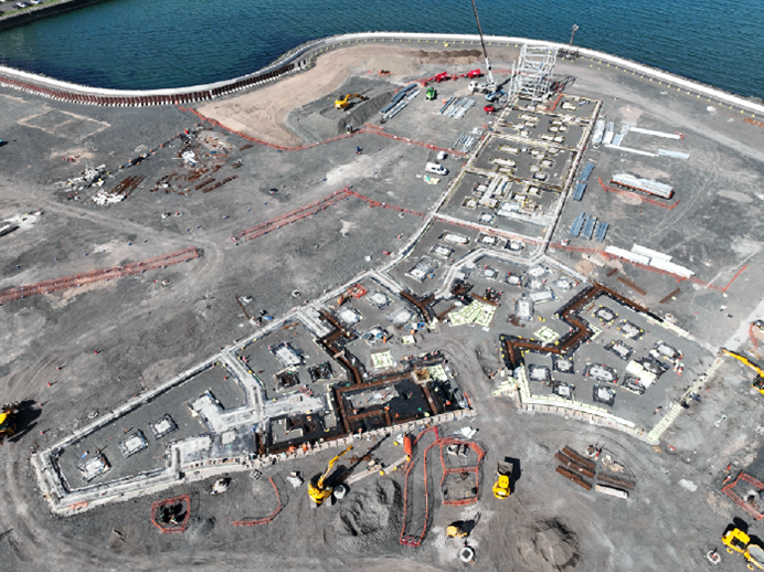 Aerial view of construction site surrounded by the sea.