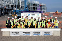 Group of people wearing high vis and hardhats on construction site with North Ayrshire and Morgan Sindall signage. 