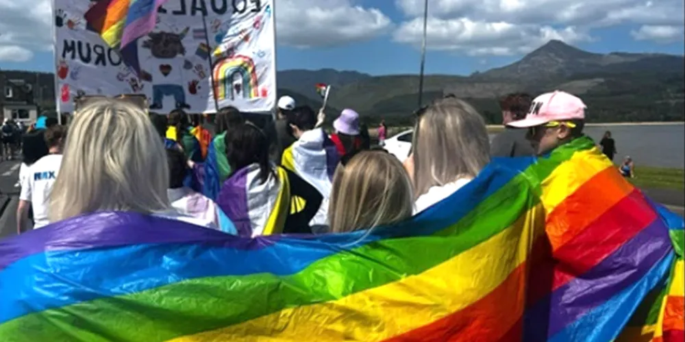 People walking with rainbow flags and signs