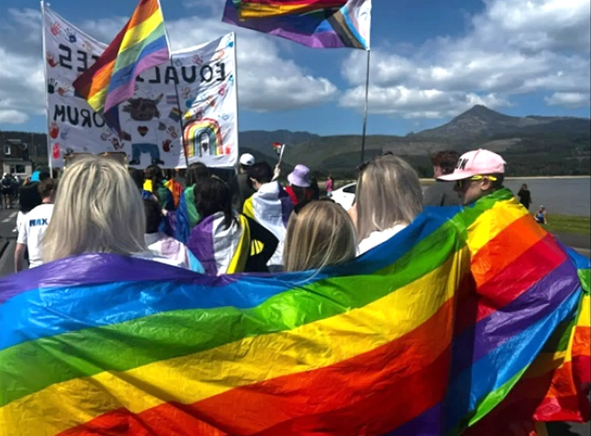 A group of young people with LGBT flags supporting the Arran Pride event in June 2024.