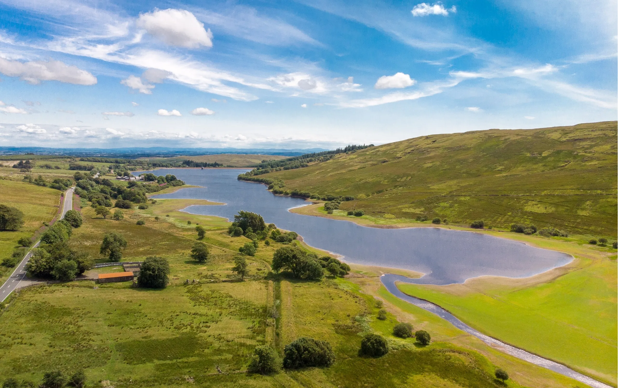 Landscape in North Ayrshire, including hills, trees, a river, a lake, road and buildings