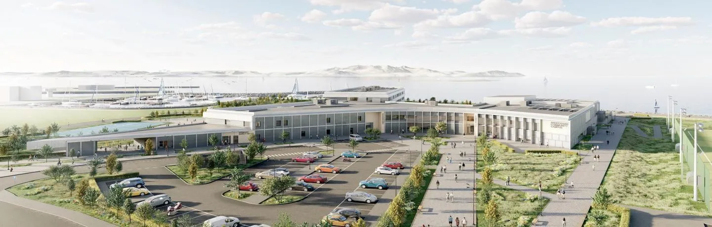 A large multi-level school which curves around a car park filled with greenery and spacious walkways. In the background, a marina sits with the Arran coastline in the distance.