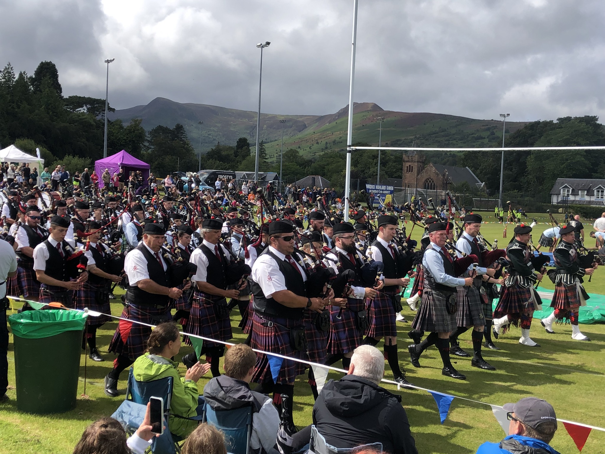 A marching highland pipe band in highland dress