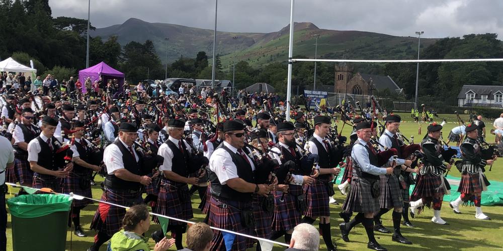 A marching highland pipe band in highland dress