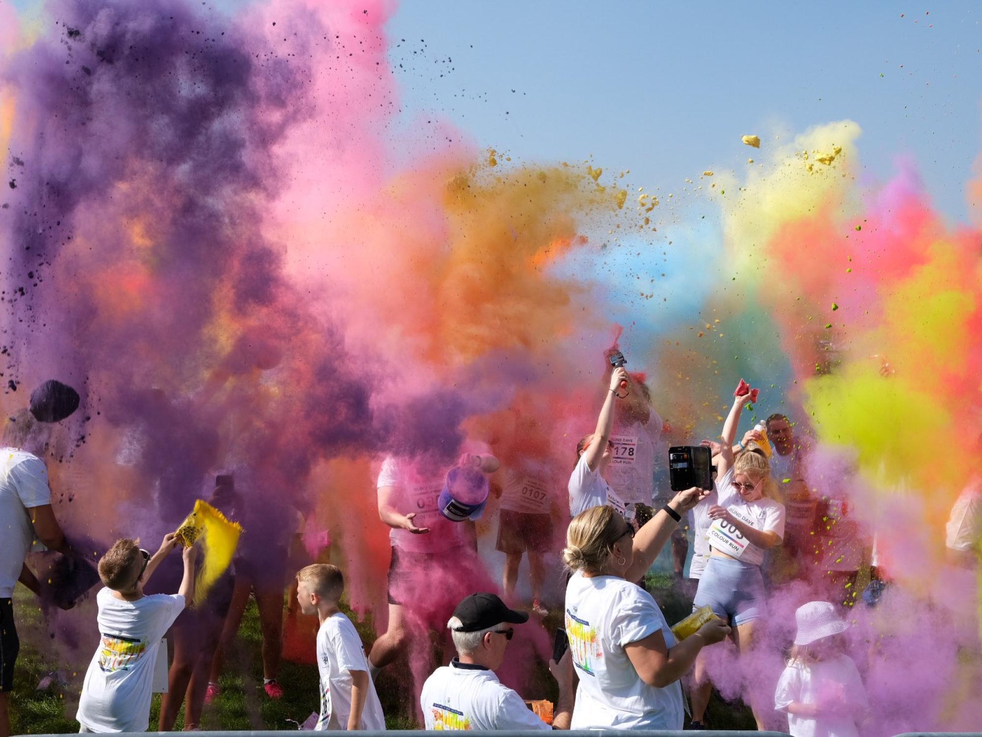 People celebrating with rainbow colour powders