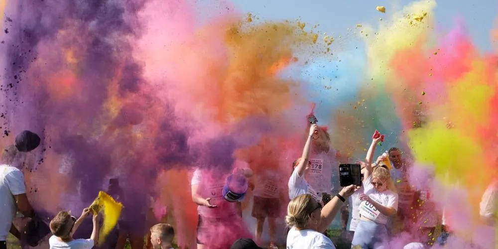 People celebrating with rainbow colour powders