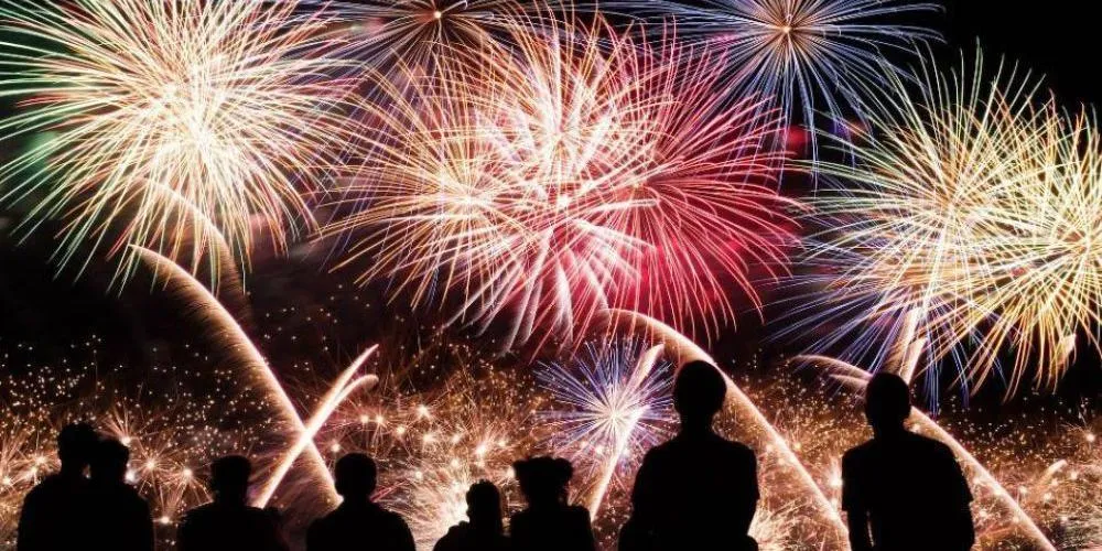 Fireworks in the sky with people watching