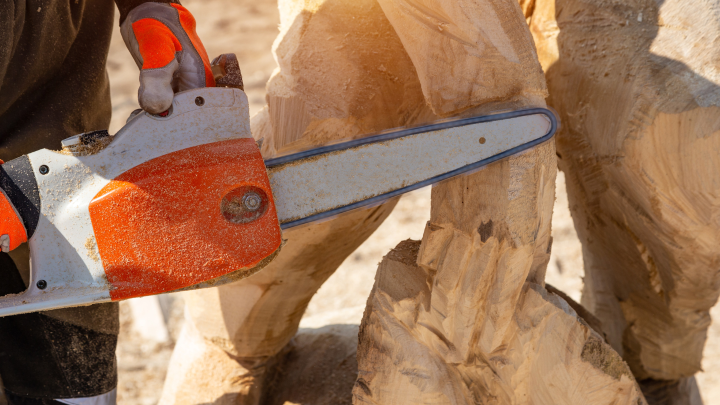 A chainsaw carves a wood sculpture
