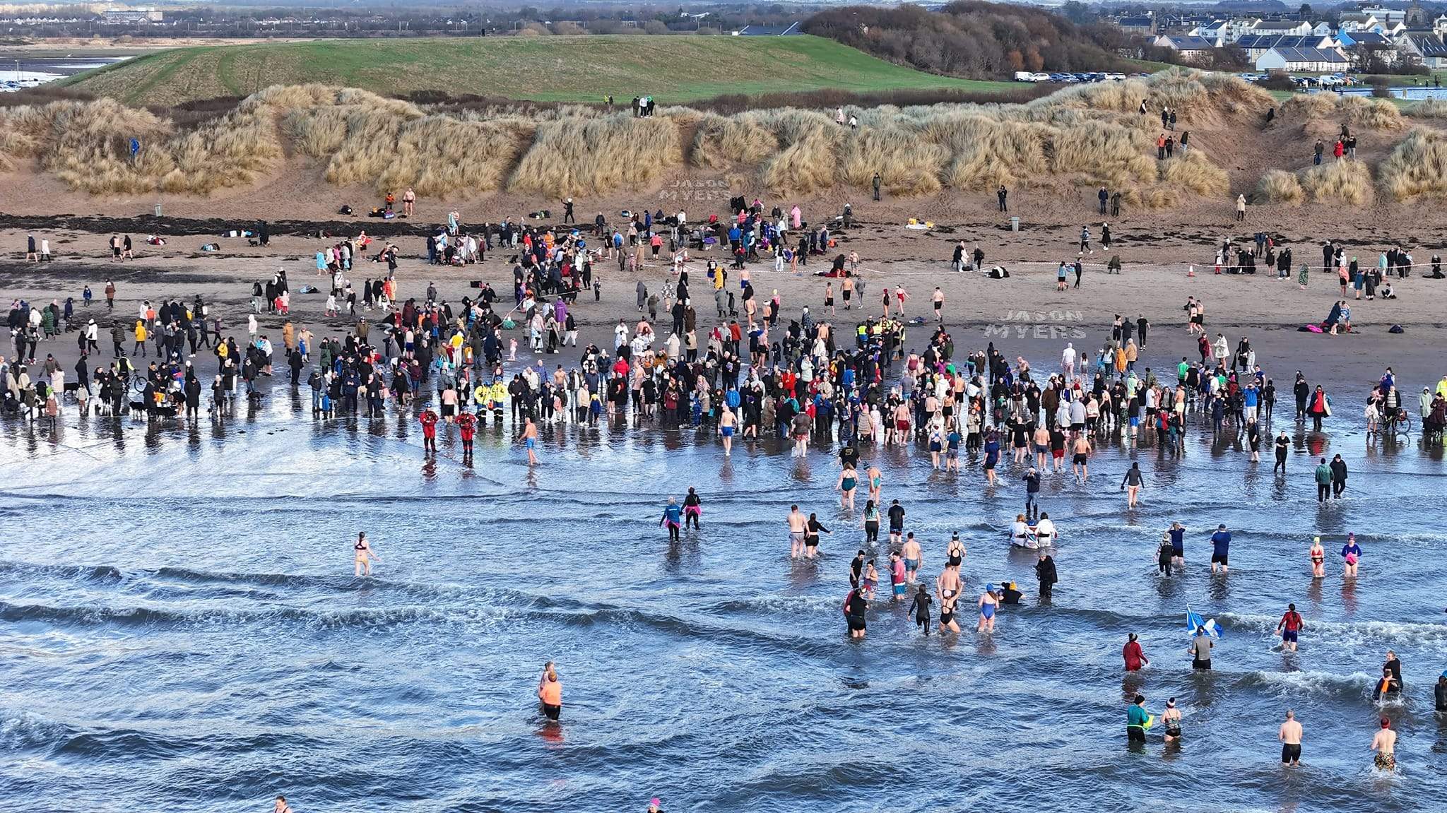 People in the water running for the shoreline