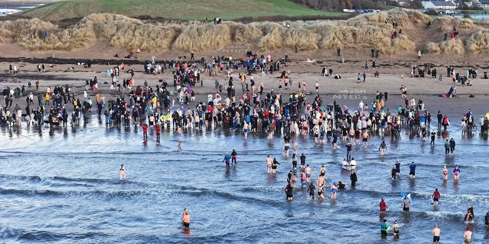 People in the water running for the shoreline