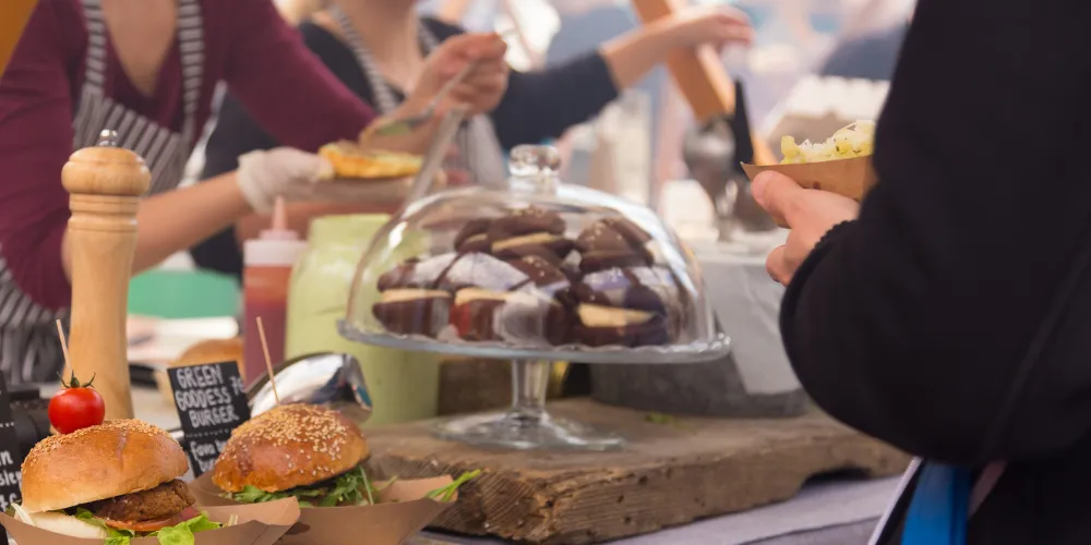 People serving food from a stall at a food festival