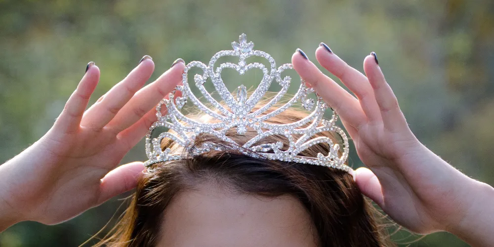 Girl placing crown on head