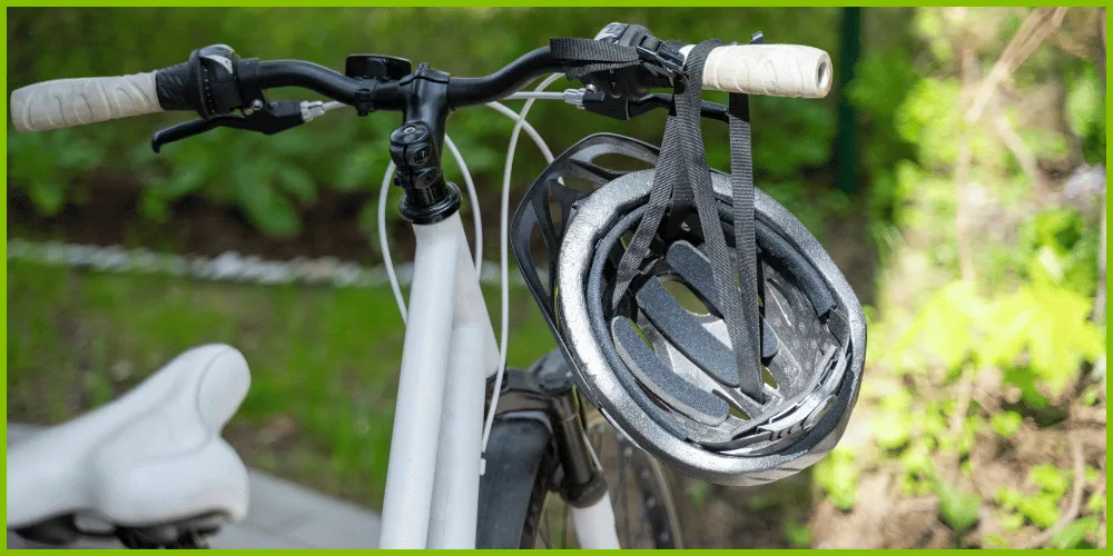 A bicycle helmet hanging on the handlebars of a bike