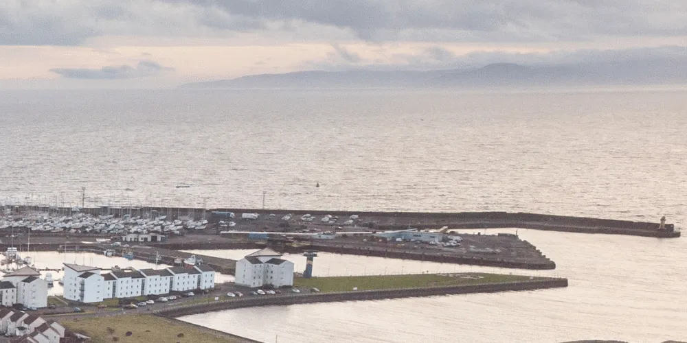 An aerial view of a harbour with the sea stretching to the horizon