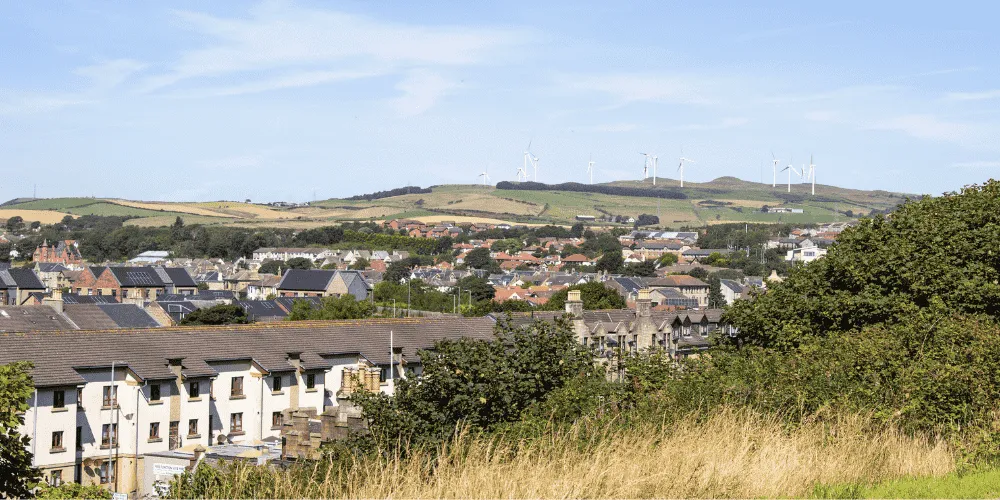 A scenic view looking across the roofs of houses to the countryside beyind