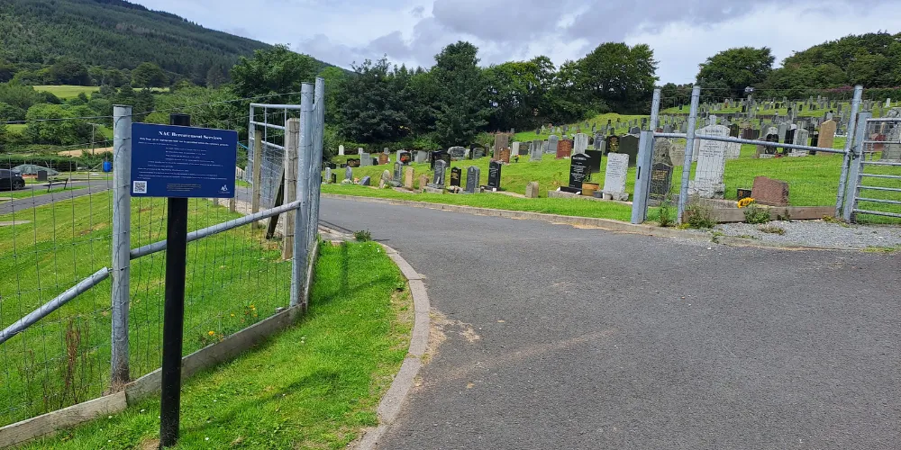 A sign at the entrance to a cemetery asking dog walkers to be respectful