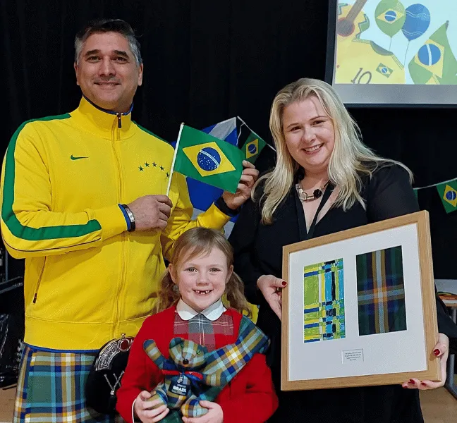 A man, woman and child standing together with lots of tartan items on display.