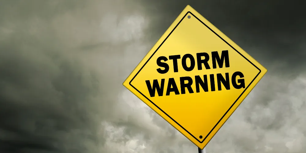 Storm warning sign against a backdrop of dark clouds