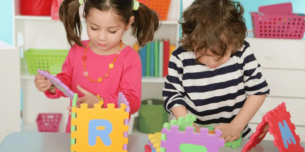 An image of two young children playing in a classroom setting