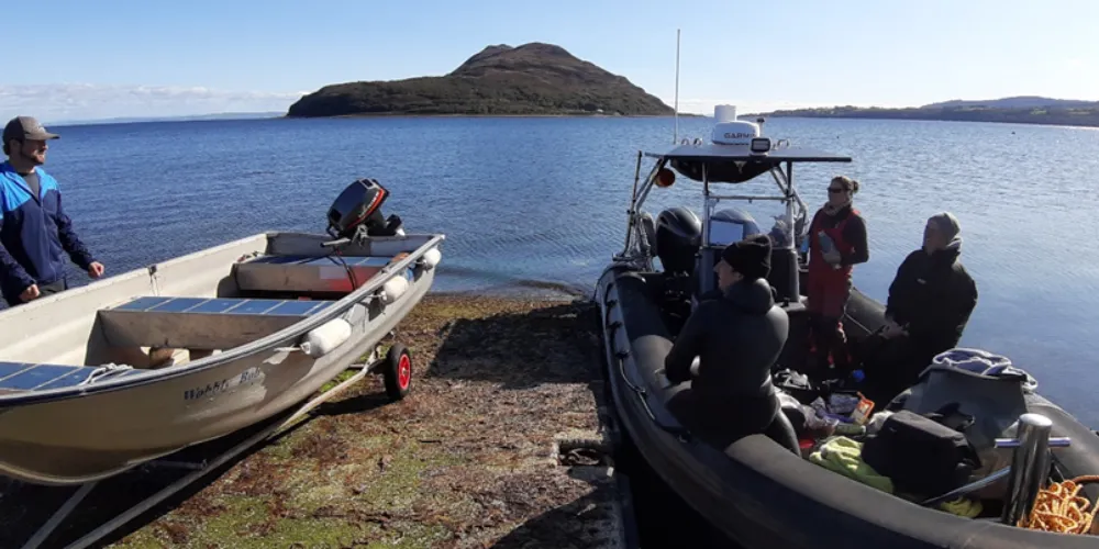 Boat on shore outside Arran Outdoor Education Centre with documentary film crew