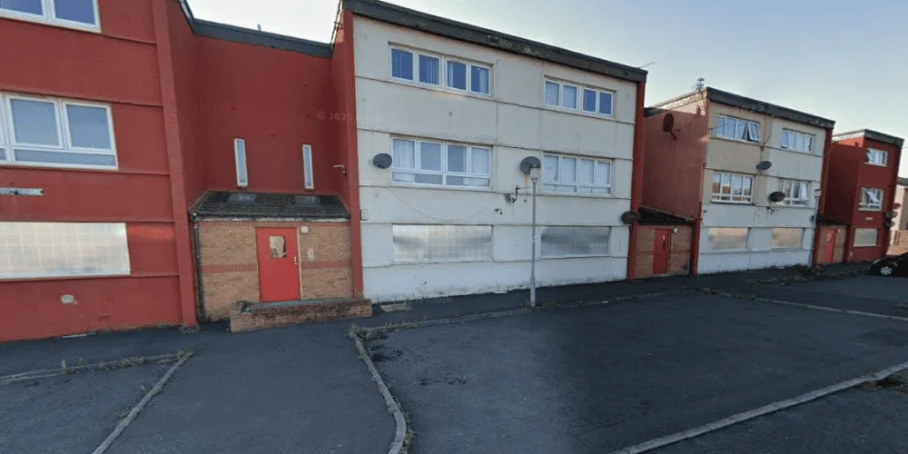 A view of a derelict block of flats with boarded up windows