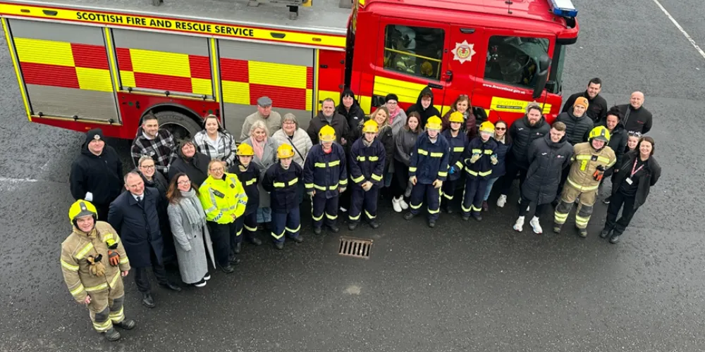Firefighters and school pupils in front of fire engine at Kilwinning Fire Station
