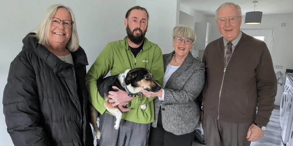 A group of four people and a dog inside a house