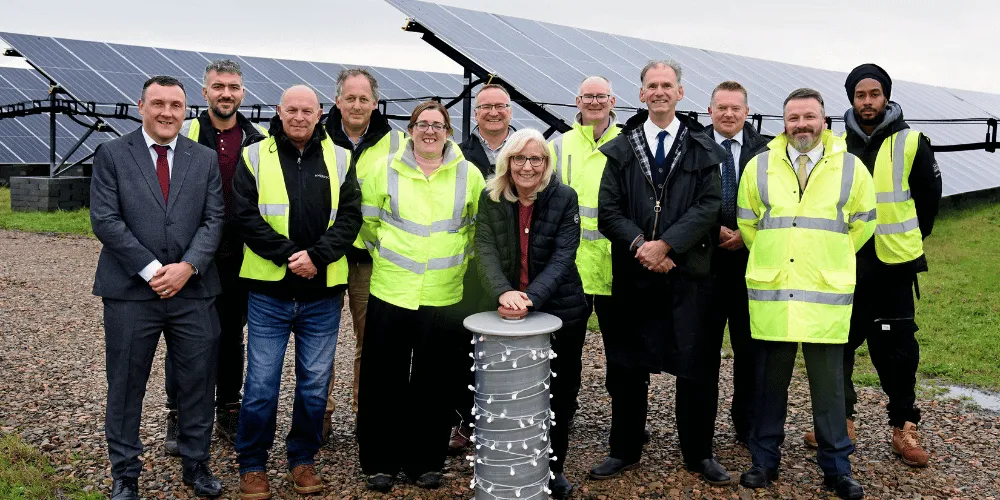 A group of people standing in a solar farm