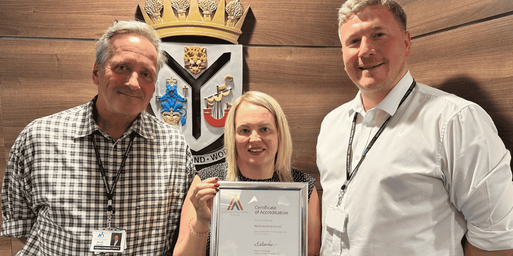 Three people holding a certificate