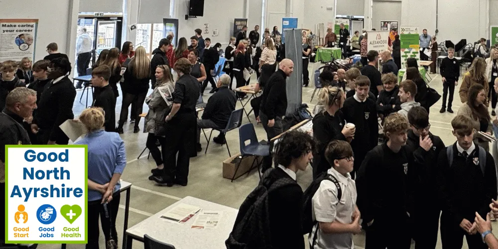 Dozens of young people browsing stalls and talking to employers at a business event