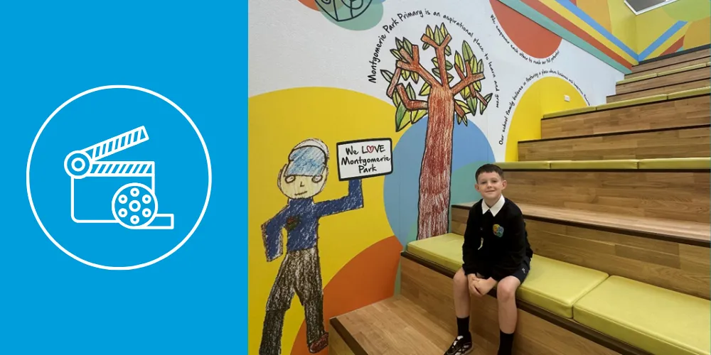 Irvine school pupil sits on stair seated area smiling