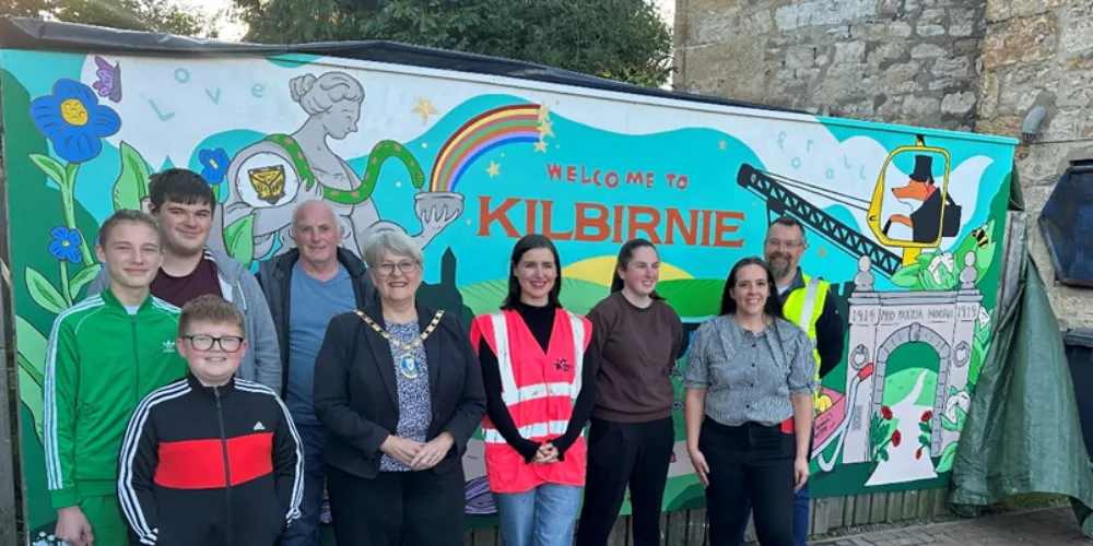 Group photo of volunteers in front of Kilbirnie wall mural