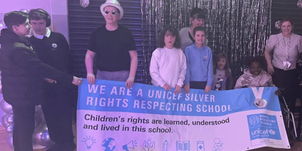A group of nine people holding a sign 