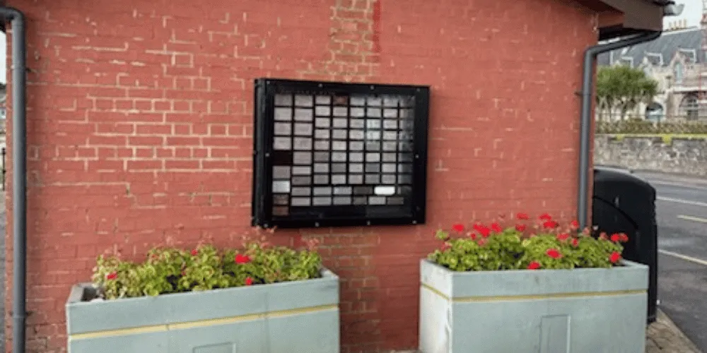 A display on the side of a small building next to a road
