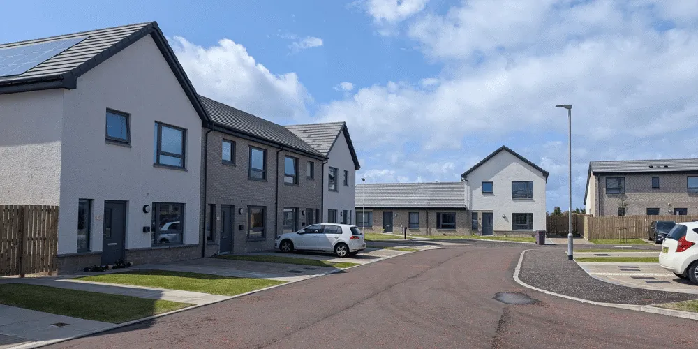 A street view of newly built houses with some cars