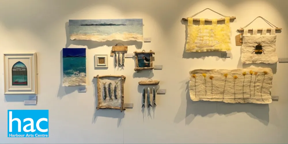 Gallery wall of paintings and felt work tapestries at Harbour Arts Centre