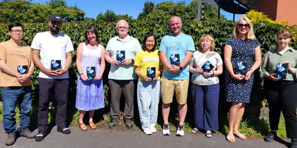 Members of a reading group standing in a line with books in their hands