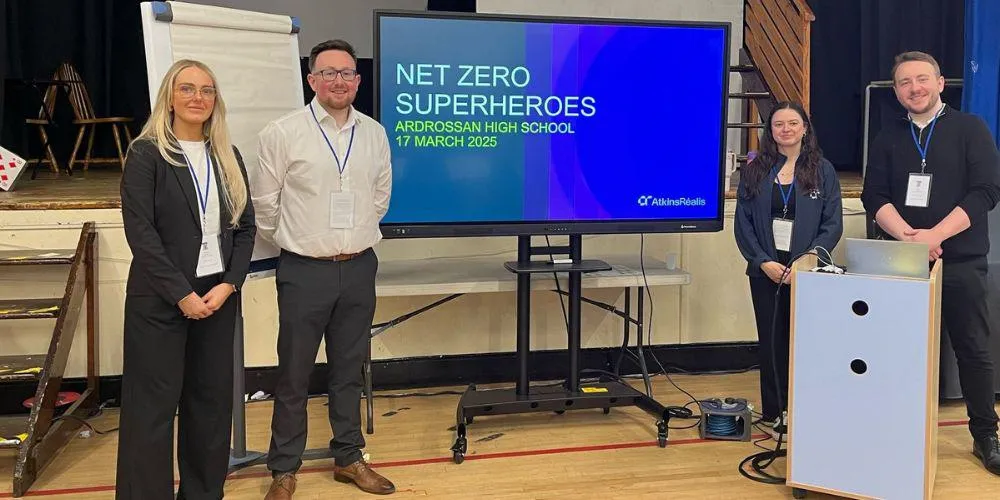 Four people stand smartly in from of presentation equipment. Net zero superheroes, Ardrossan High School, 17 March 2025