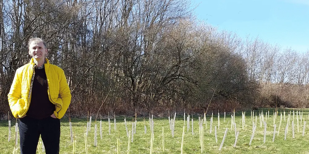 Councillor Tony Gurney standing in front of recently-planted trees