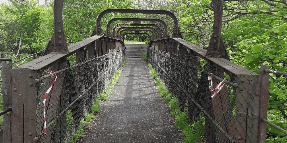 A view looking along a pedestrian footbridge in a state of disrepair