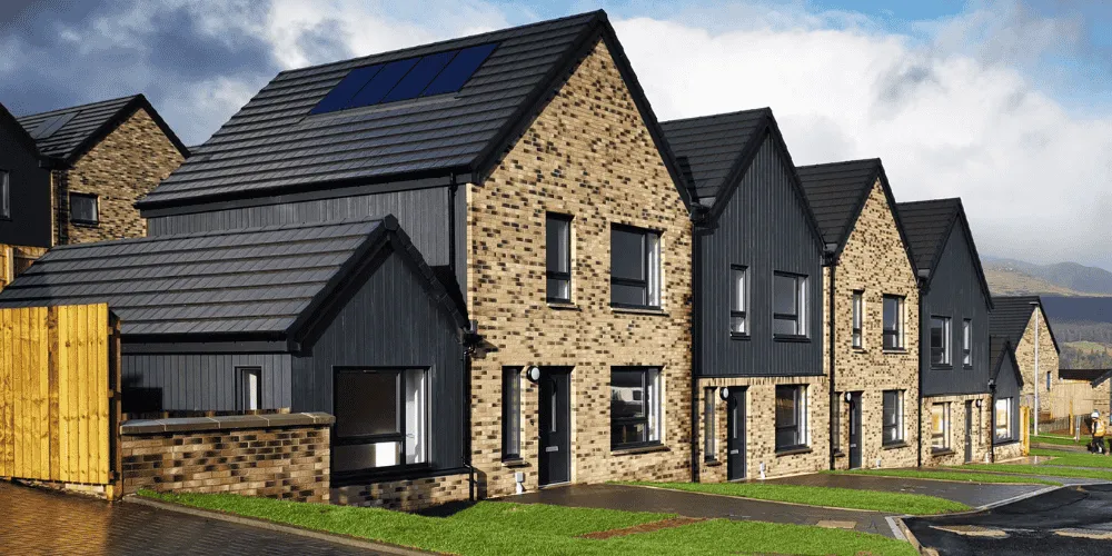 a view of a row of newly-built homes with hills in the background