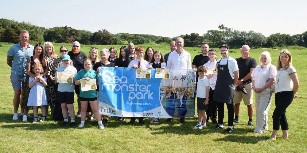 Young people and partners with Sea Monster Park banner