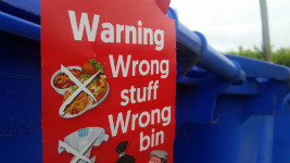 Blue wheelie bin with red warning tag attached